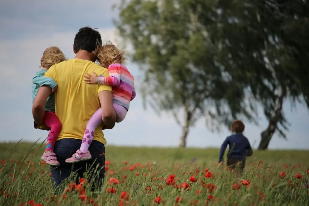 father holding children on hips